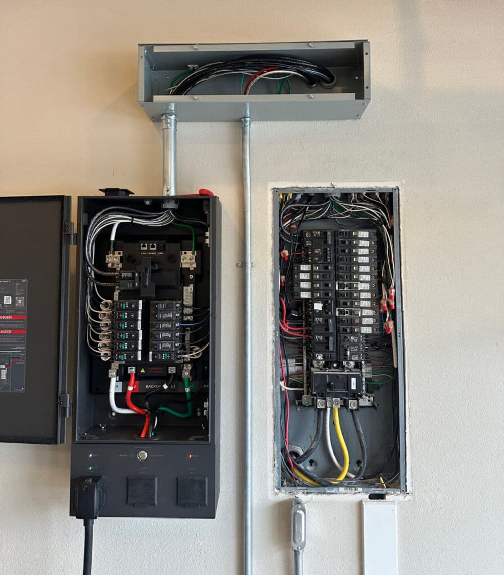 Electrical panel and circuit breaker box with visible wiring in a residential setting.