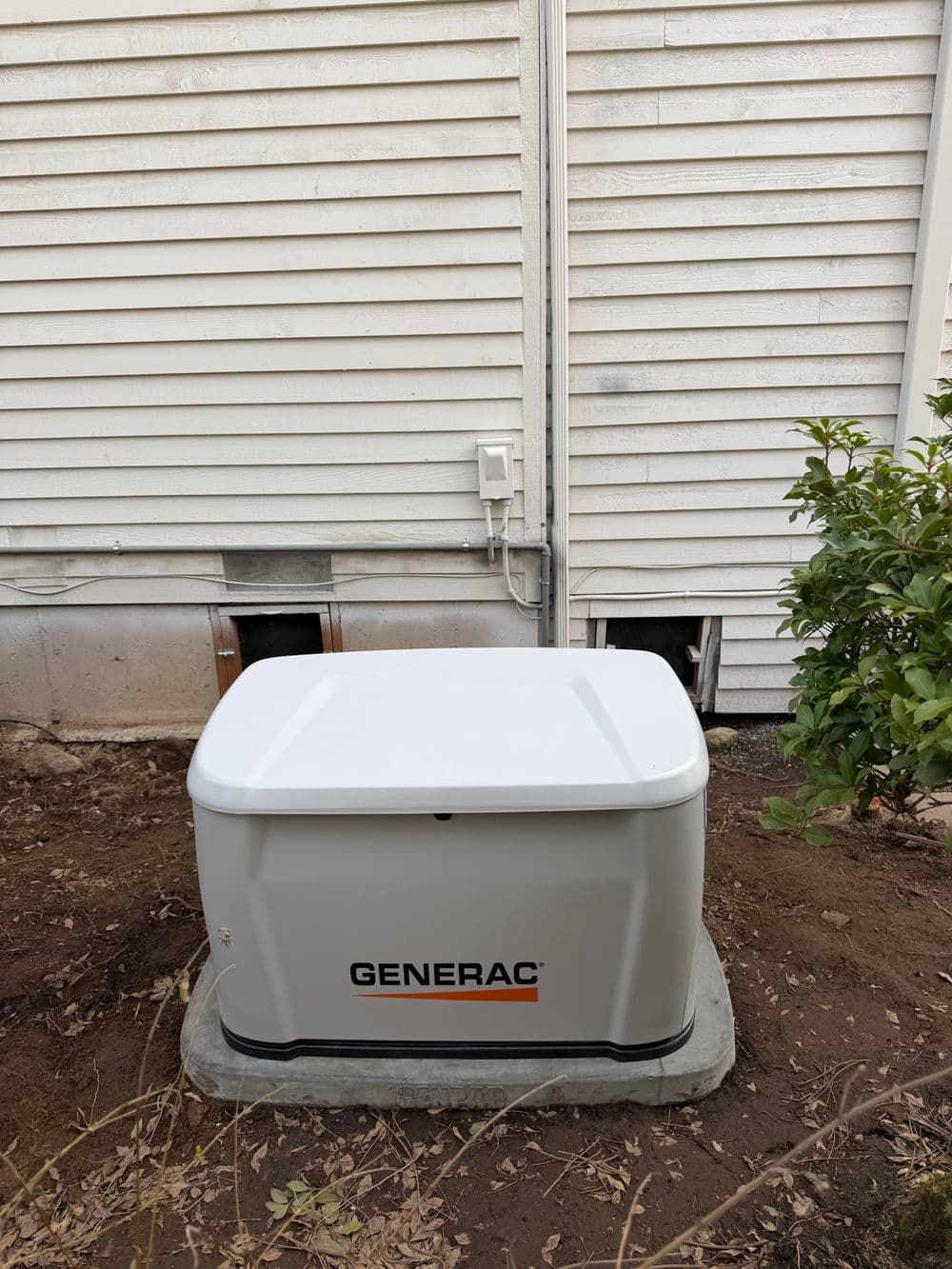 Generac home generator installed beside a house, ensuring reliable backup power.